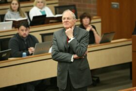 A man teaches in front of students.